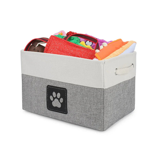 Gray storage bin with a paw print logo filled with colorful pet toys on a white background