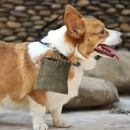 Corgi dog with a green bag hanging from its mouth against a stone wall background