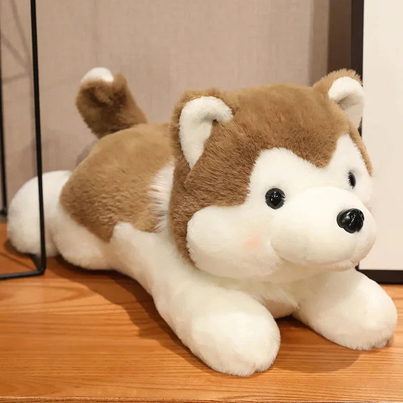 Plush toy dog with brown and white fur on a wooden surface