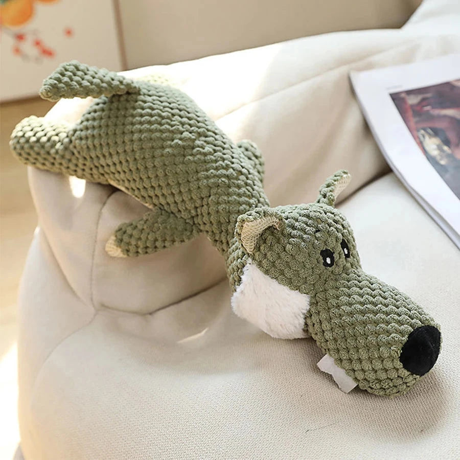 Green knitted dog toy on a beige couch