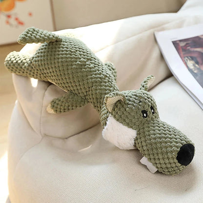 Green knitted dog toy on a beige couch